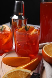 Photo of Aperol spritz cocktail, rosemary and orange slices on white table, closeup