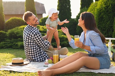 Happy family having picnic in garden on sunny day