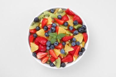 Yummy fruit salad in bowl on light background, top view
