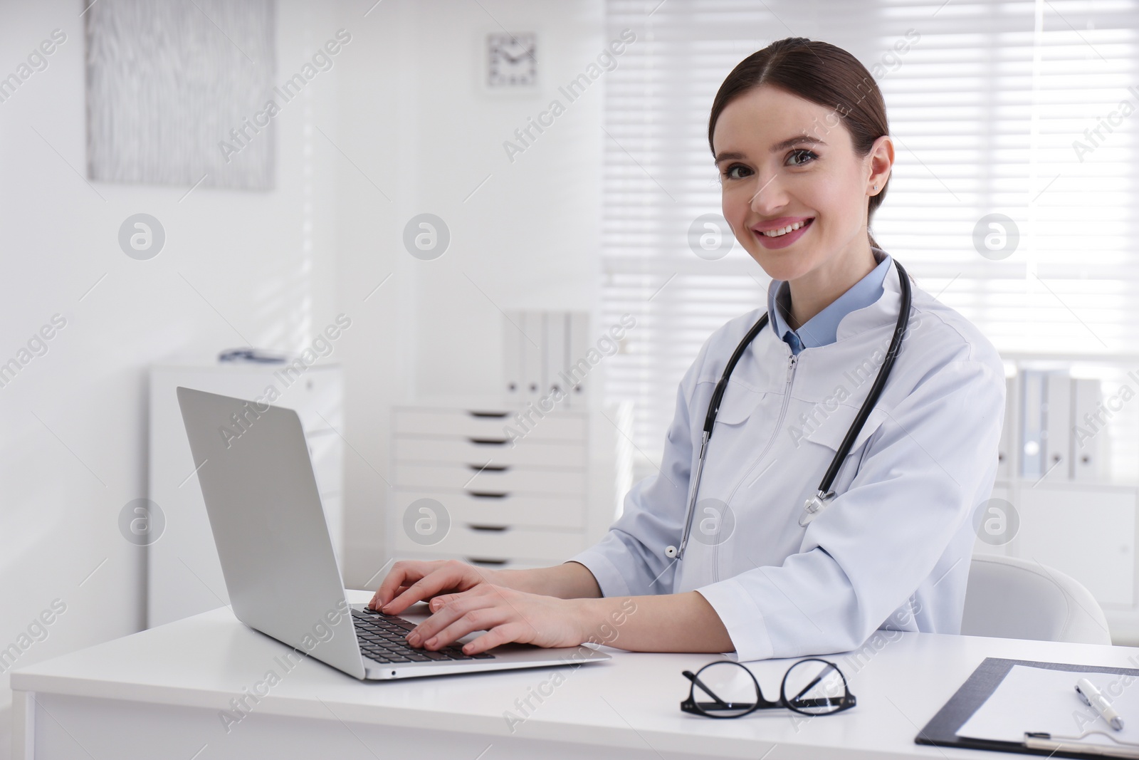 Photo of Portrait of young female doctor in white coat at workplace