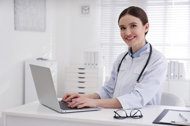 Photo of Portrait of young female doctor in white coat at workplace