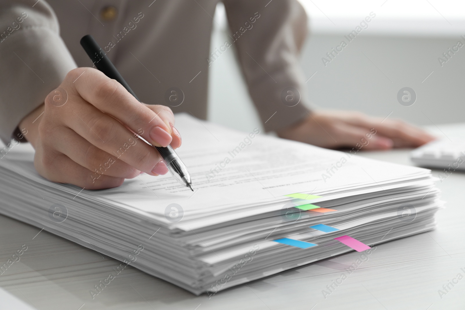 Photo of Woman signing documents at table in office, closeup