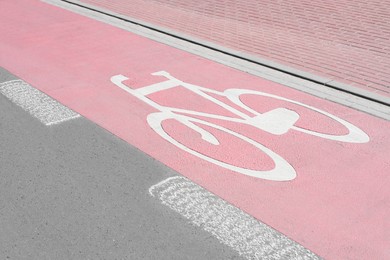 Red bike lane with painted white bicycle sign on sunny day