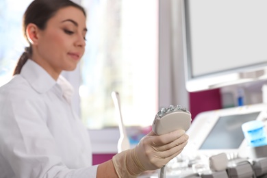 Sonographer holding ultrasound machine probe with gel in clinic