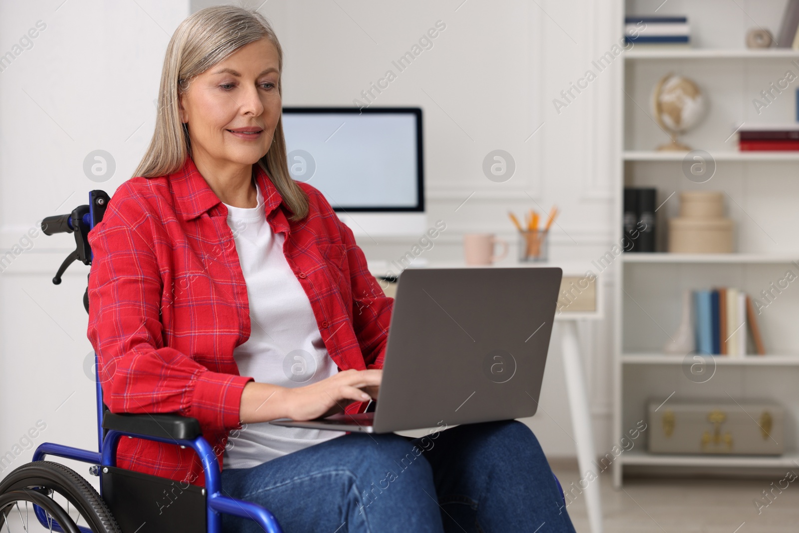 Photo of Woman in wheelchair using laptop at home