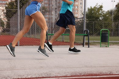 Photo of Healthy lifestyle. Sporty couple running outdoors, closeup with space for text