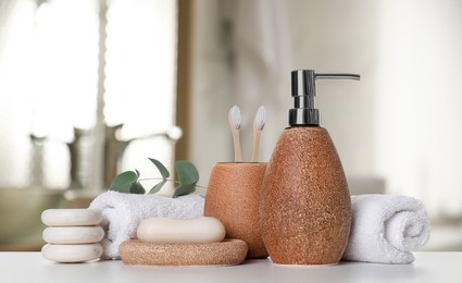 Image of Bath accessories. Different personal care products and eucalyptus leaves on white table in bathroom, banner design