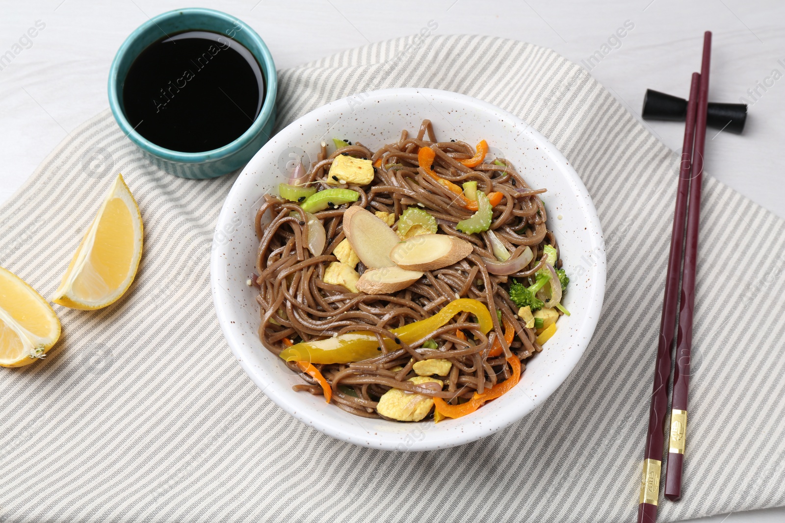 Photo of Stir-fry. Delicious cooked noodles with chicken and vegetables in bowl served on light table, flat lay