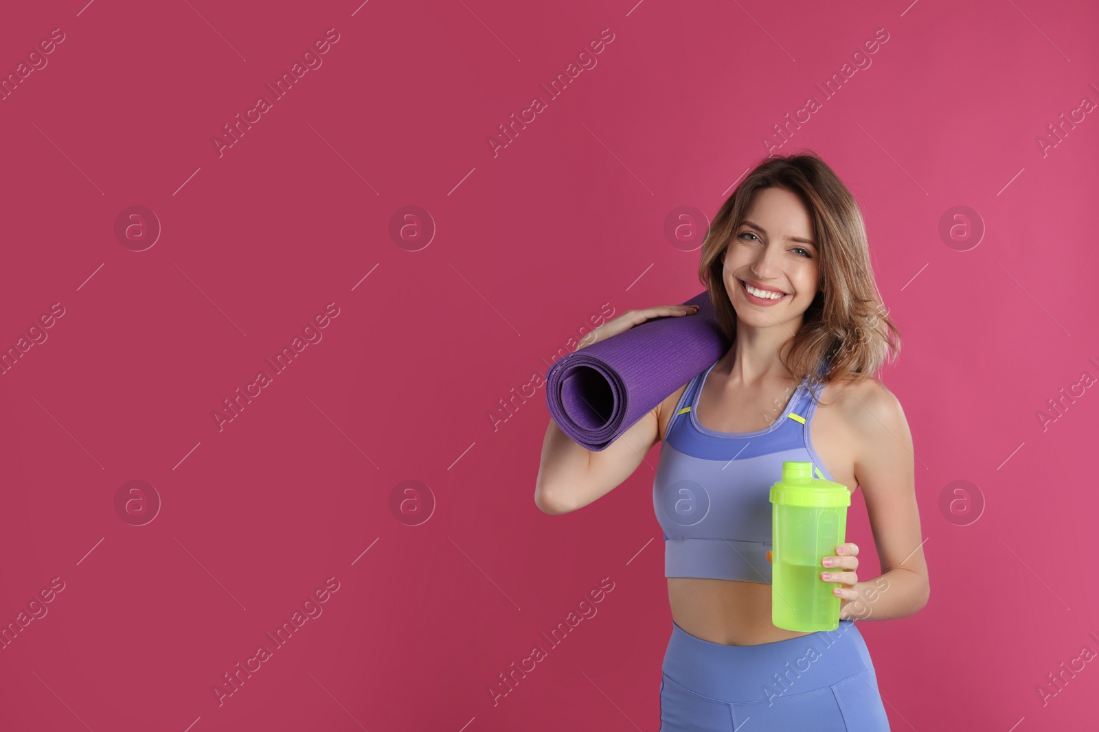 Photo of Beautiful woman with yoga mat and shaker on pink background. Space for text