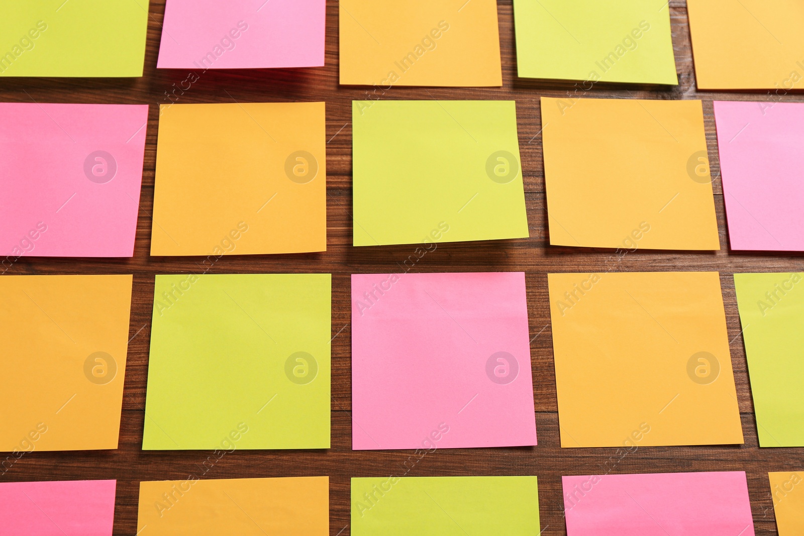 Photo of Many colorful stickers on wooden background, above view