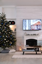 Photo of Stylish living room interior with modern TV, fireplace and Christmas tree