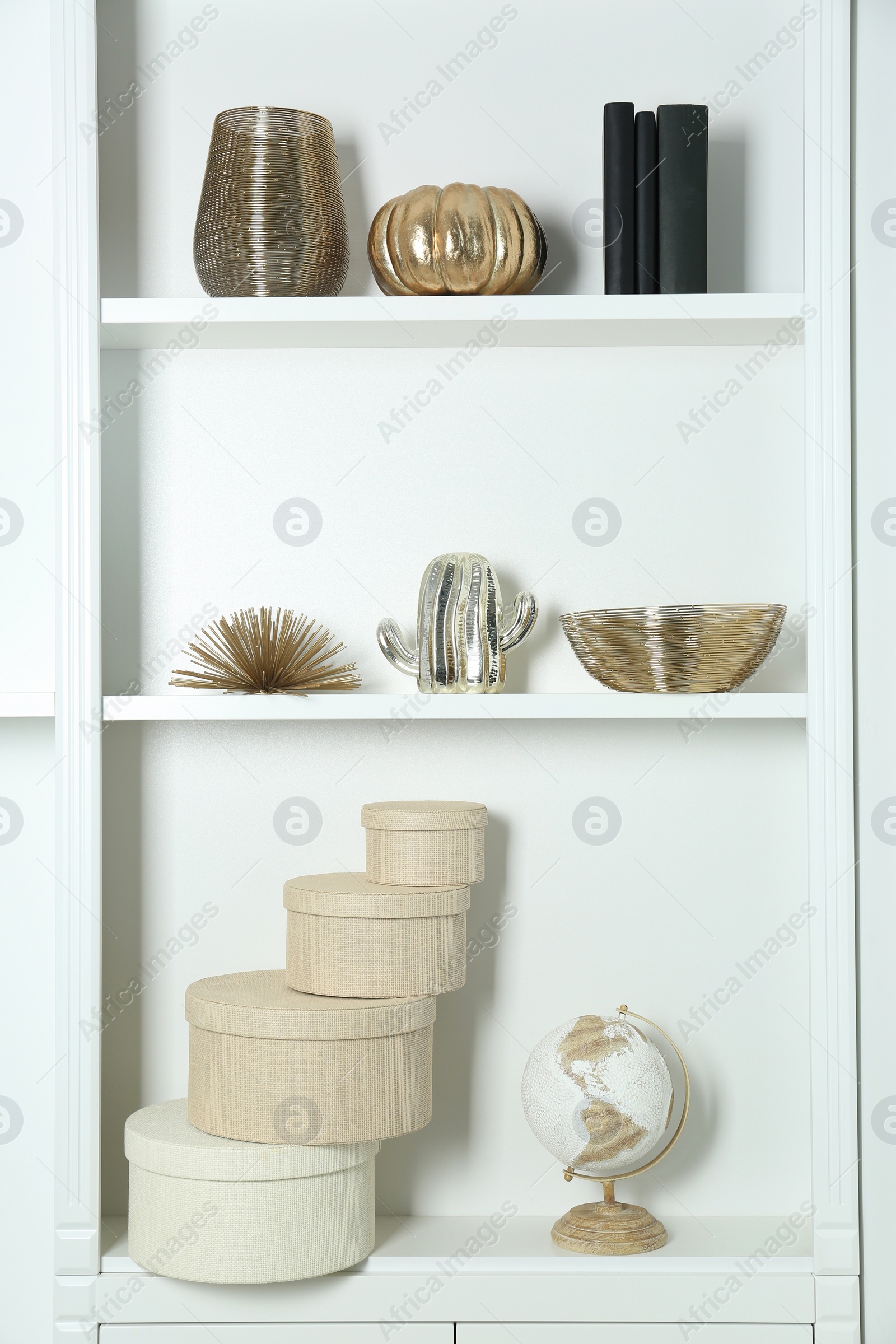 Photo of White shelves with books and different decor indoors. Interior design