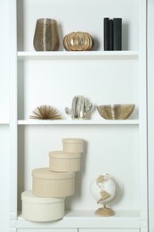 White shelves with books and different decor indoors. Interior design