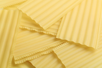 Photo of Pile of uncooked lasagna sheets as background, closeup