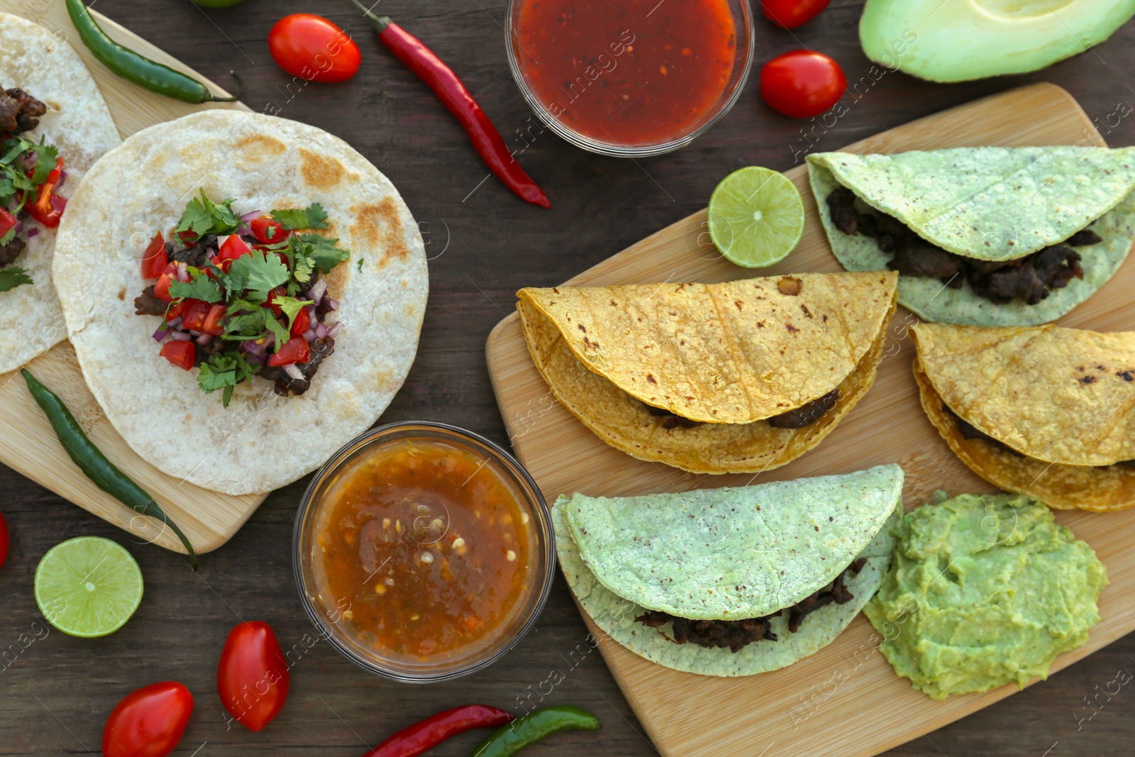 Photo of Delicious tacos and ingredients on wooden table, flat lay. Mexican food