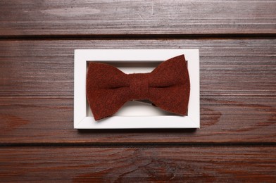 Stylish bow tie on wooden background, top view