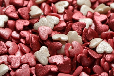 Photo of Sweet candy hearts as background, closeup view