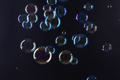 Photo of Beautiful transparent soap bubbles on dark background