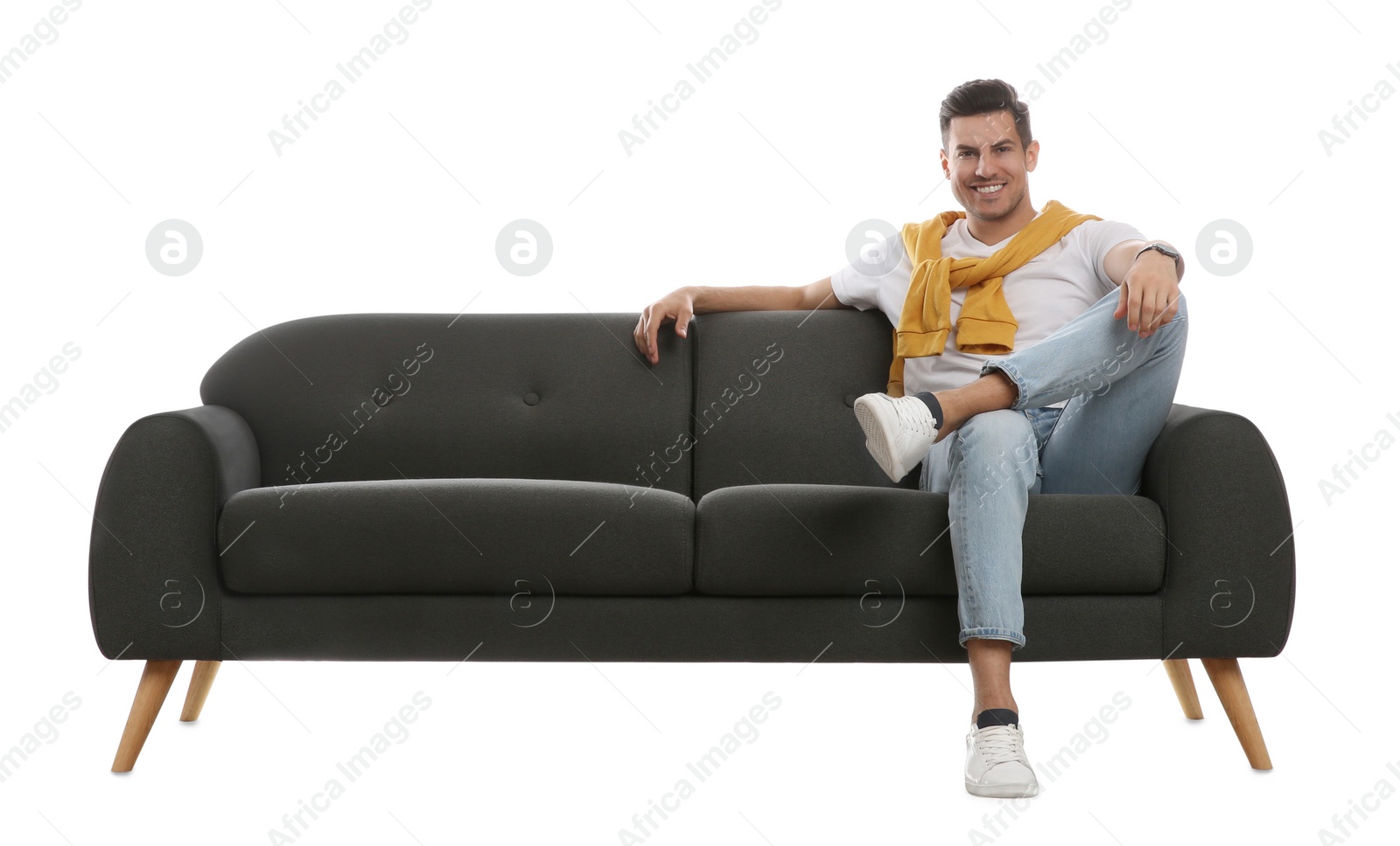 Photo of Man relaxing on comfortable grey sofa against white background