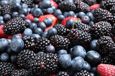 Photo of Mix of different ripe tasty berries as background, closeup view