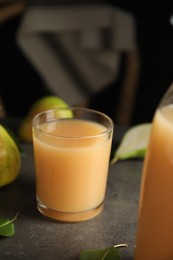 Photo of Fresh pear juice in glass on grey table