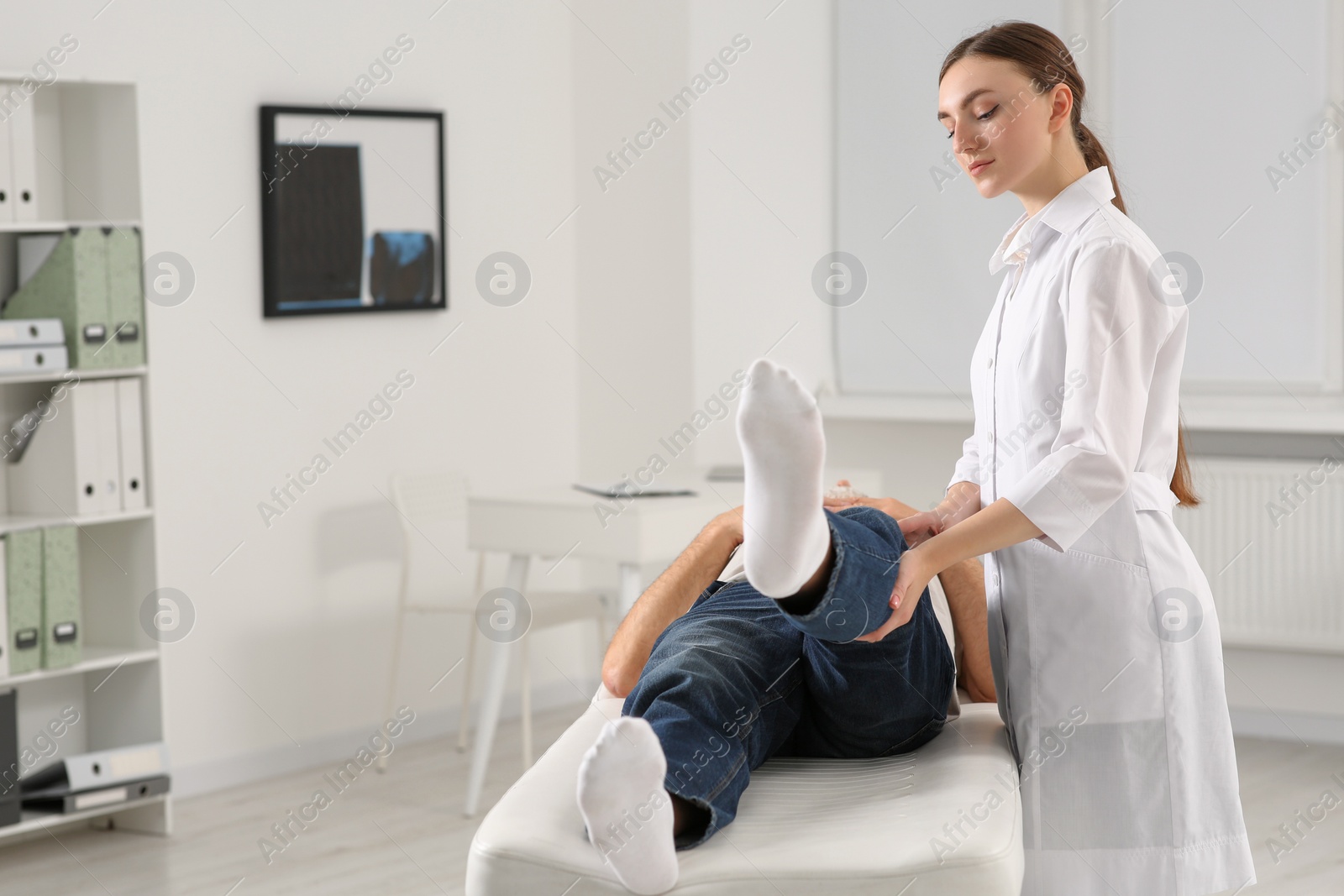 Photo of Professional orthopedist examining patient's leg in clinic