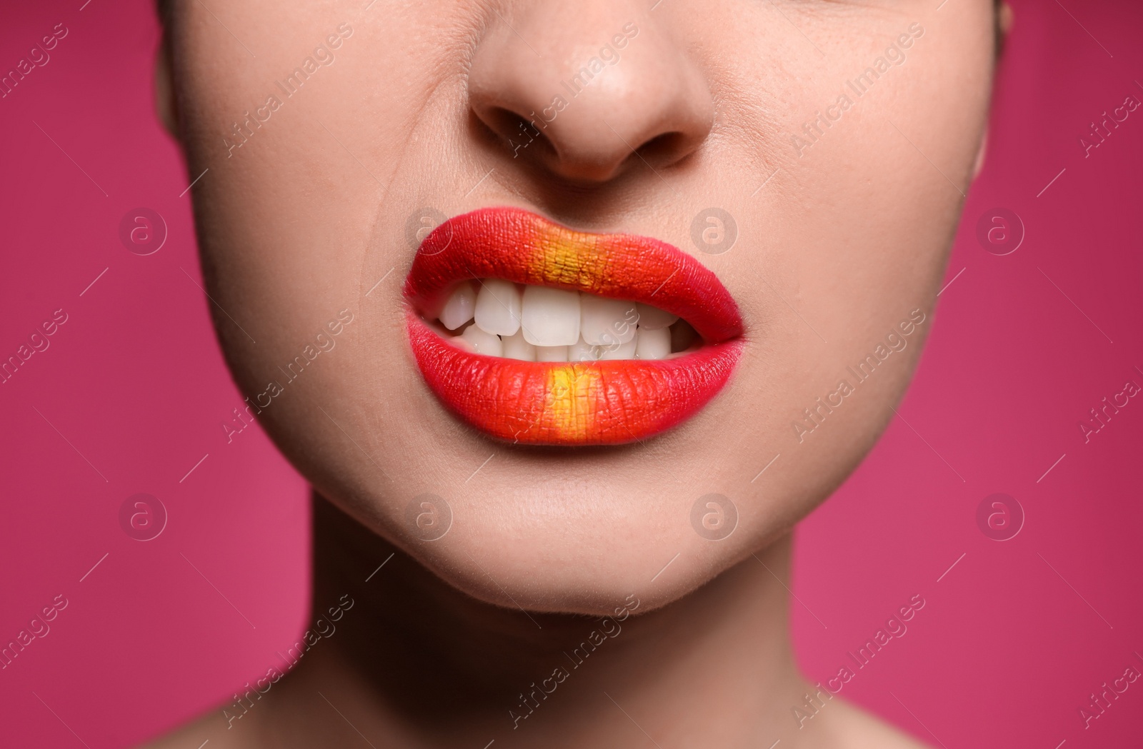 Photo of Young woman with beautiful lips makeup on pink background, closeup