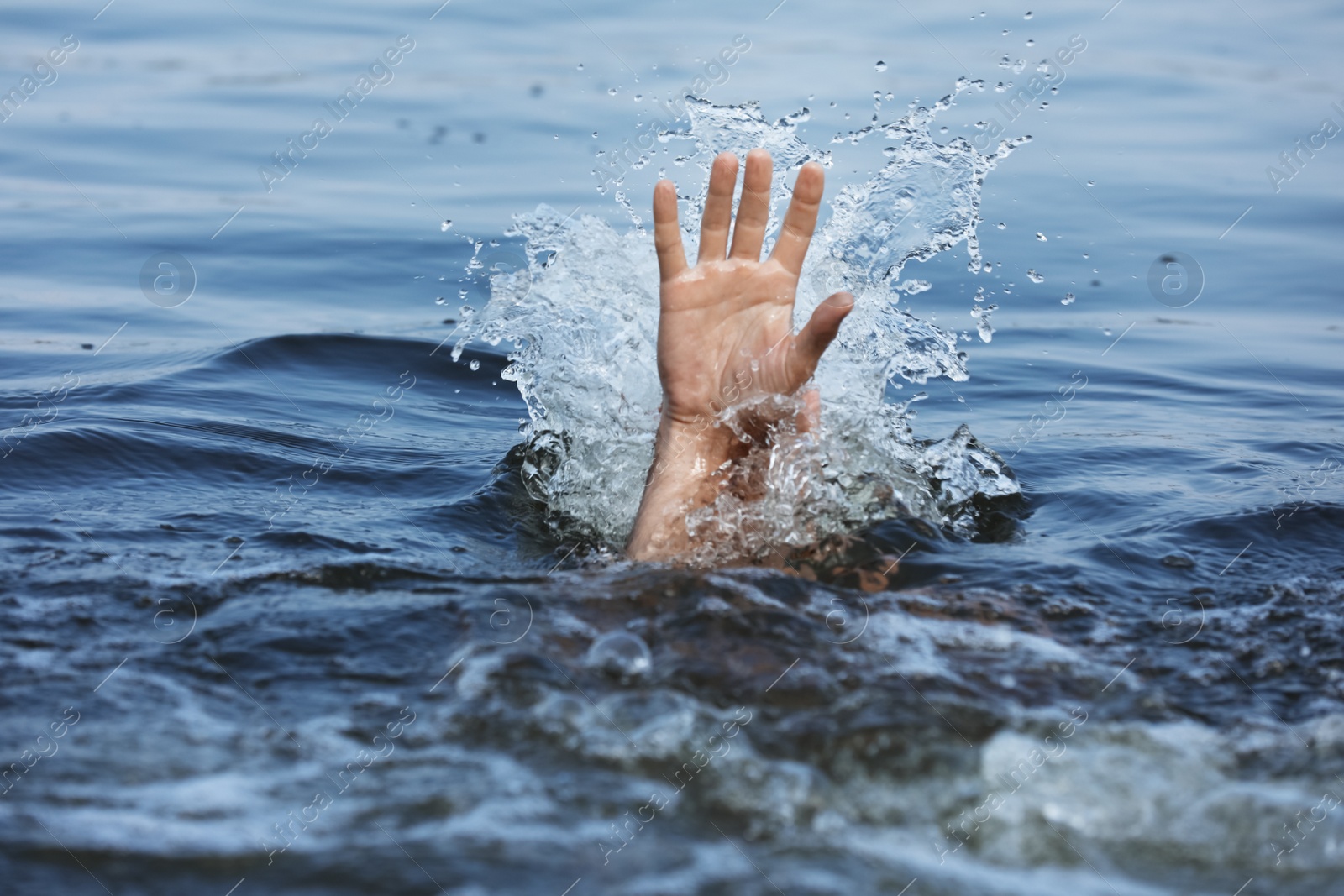 Photo of Drowning man reaching for help in sea, closeup