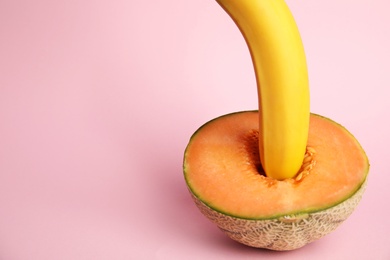 Photo of Fresh melon and banana on pink background, space for text. Sex concept