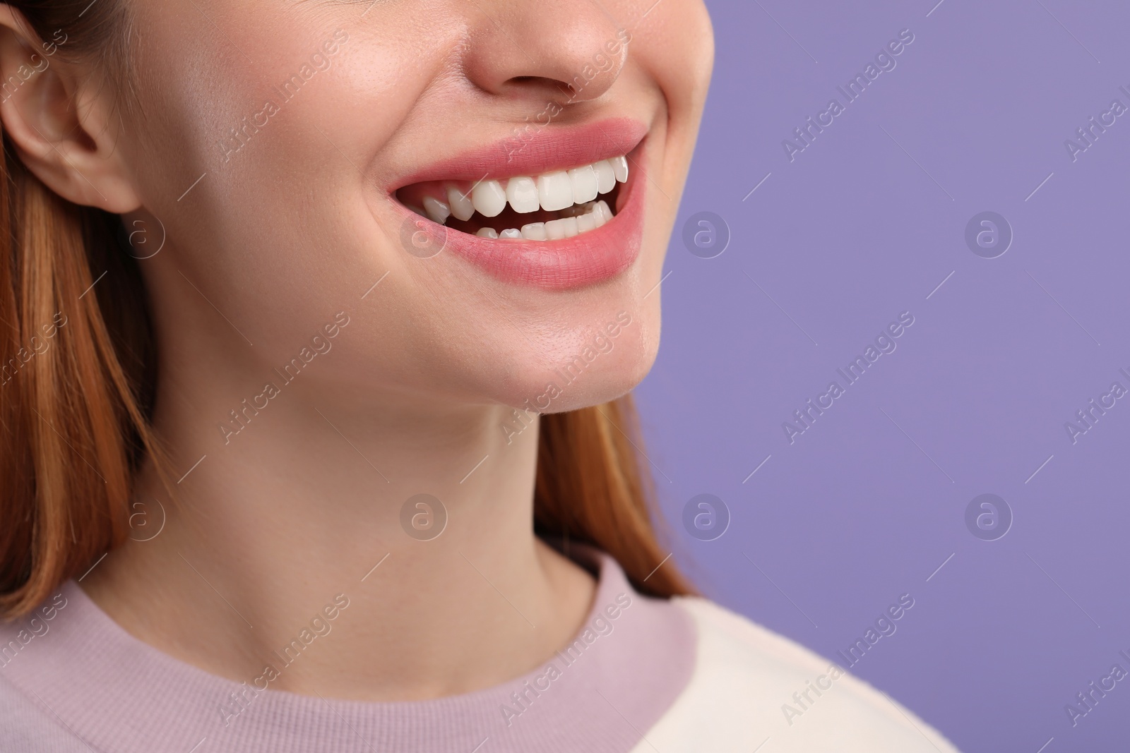 Photo of Woman with clean teeth smiling on violet background, closeup. Space for text