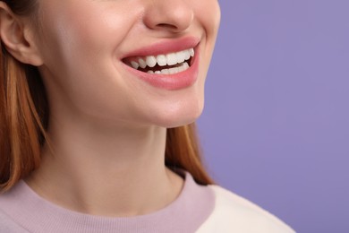 Woman with clean teeth smiling on violet background, closeup. Space for text