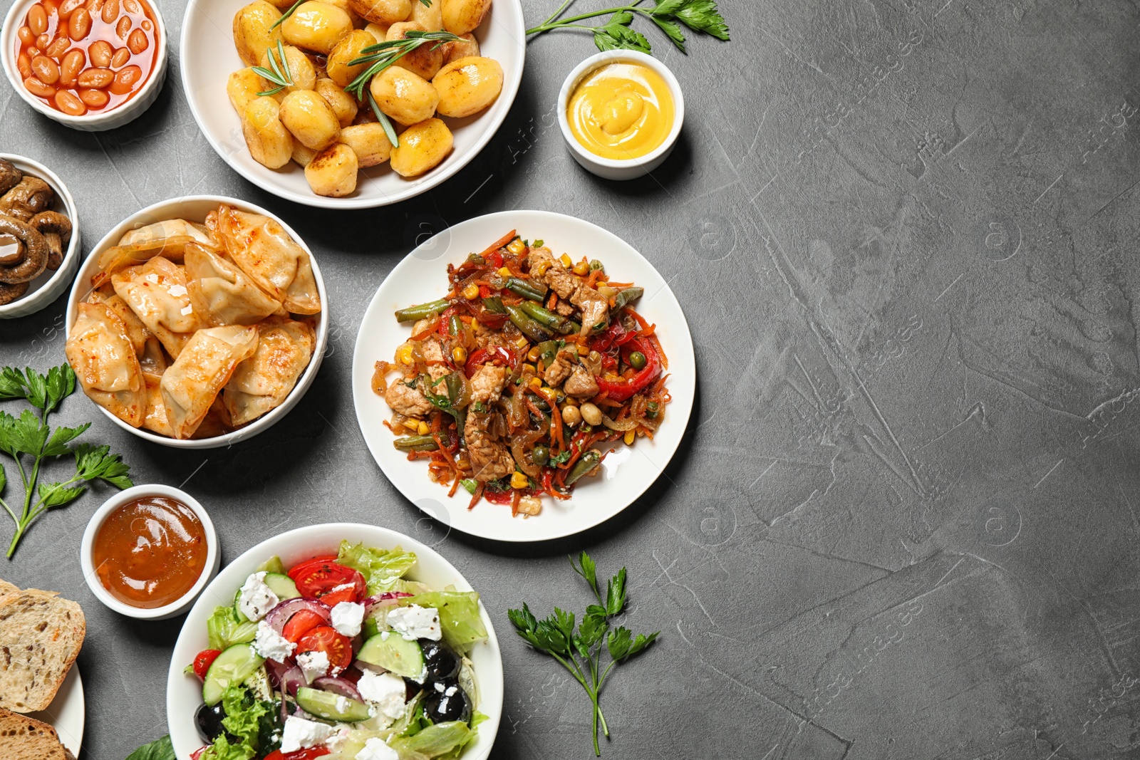 Photo of Buffet service. Flat lay composition with many  different dishes on grey table, space for text