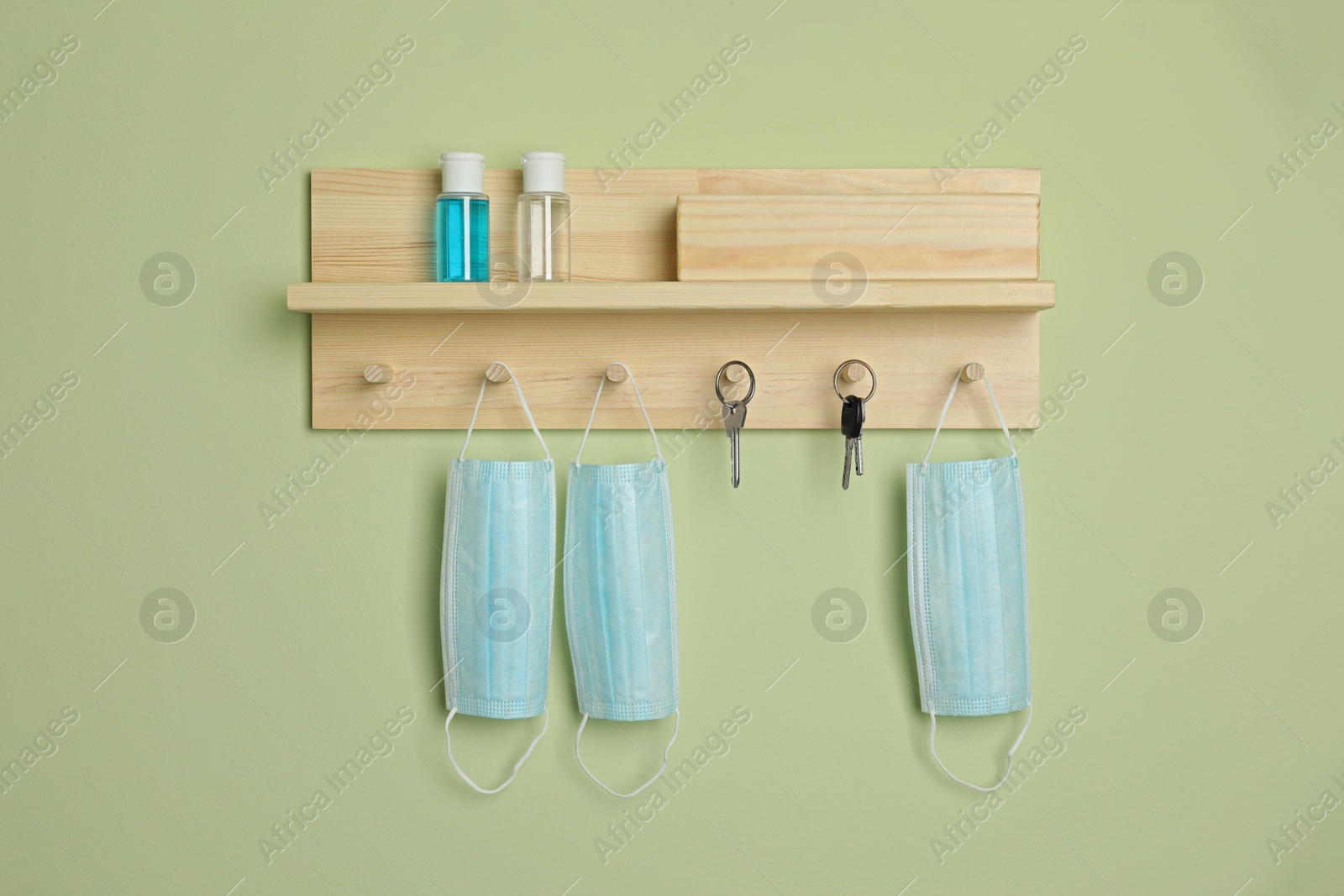 Photo of Wooden hanger for keys on light green wall