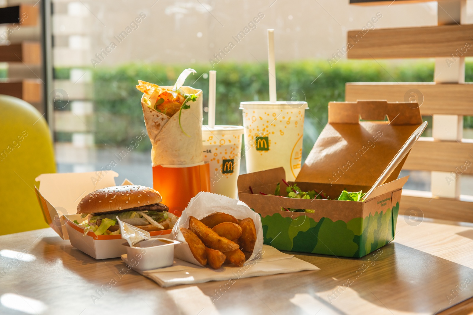 Photo of WARSAW, POLAND - SEPTEMBER 16, 2022: Big Mac hamburger, fried potatoes and cold drinks on table in McDonald's cafe