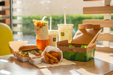 Photo of WARSAW, POLAND - SEPTEMBER 16, 2022: Big Mac hamburger, fried potatoes and cold drinks on table in McDonald's cafe