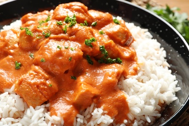 Photo of Delicious butter chicken with rice in pan, closeup