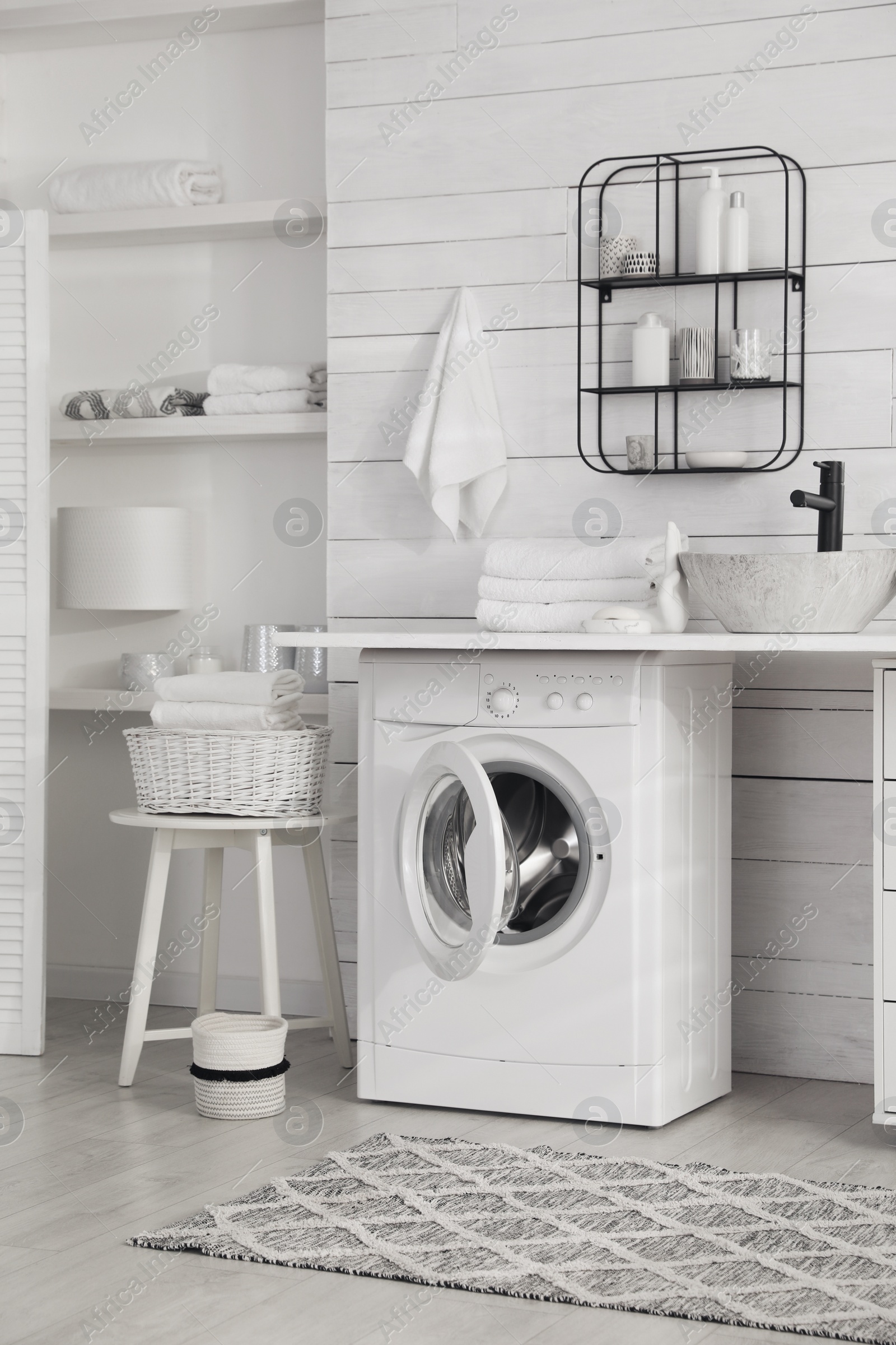 Photo of Stylish bathroom interior with modern washing machine