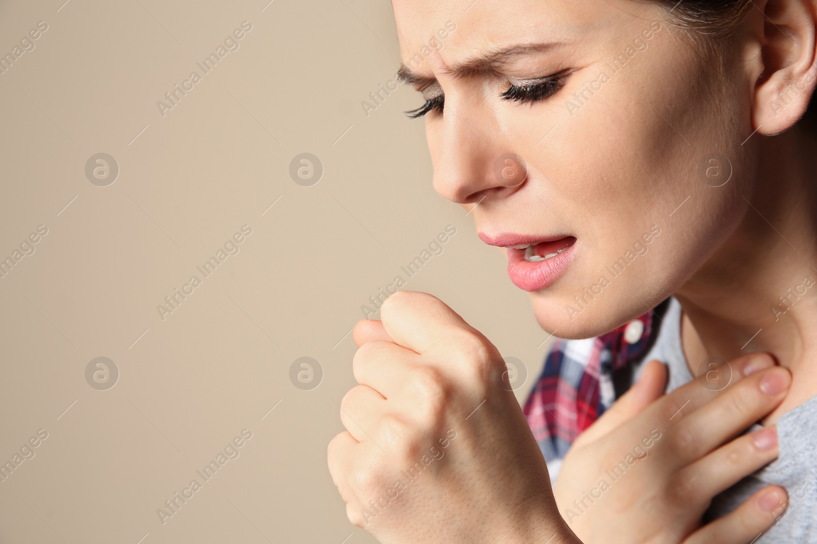 Photo of Woman suffering from cough on color background. Space for text