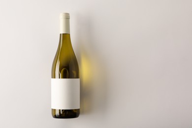 Photo of Bottle of tasty wine on white background, top view. Space for text
