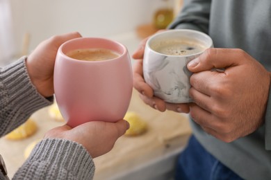 Couple drinking coffee at home, closeup view