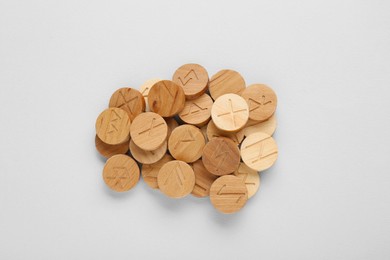 Pile of wooden runes on white background, top view