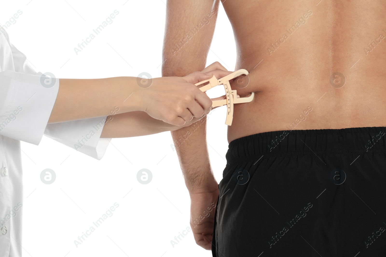 Photo of Nutritionist measuring man's body fat layer with caliper on white background, closeup