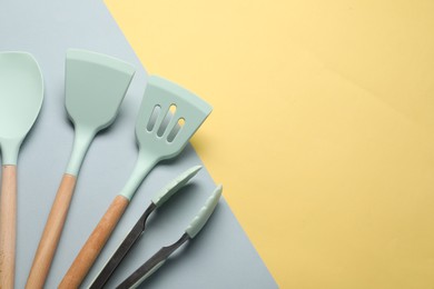 Photo of Different spatulas and tongs on color background, flat lay. Space for text