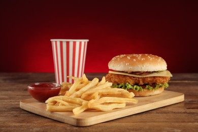 Photo of Delicious fast food menu on wooden table against red background