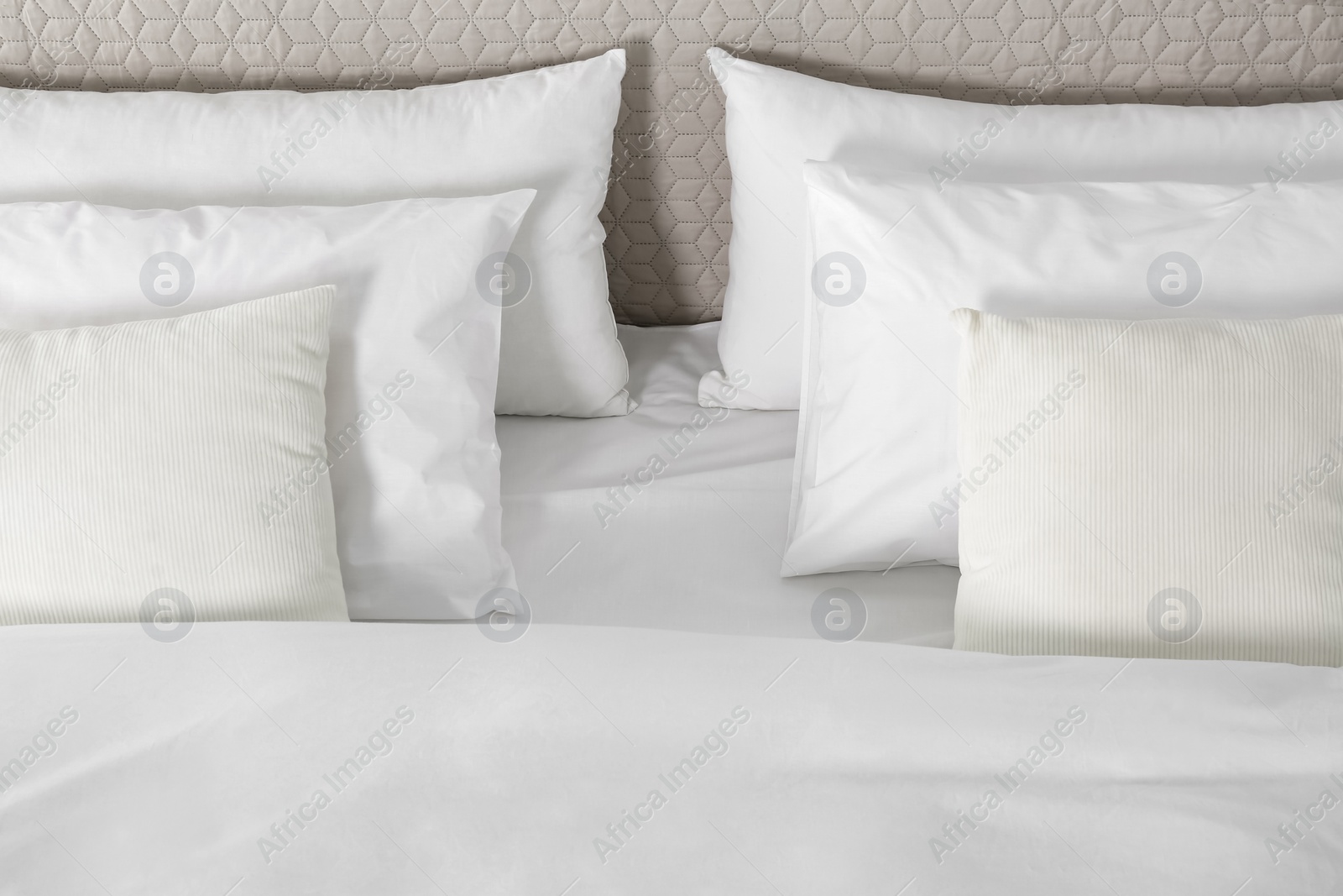 Photo of Bed with soft fluffy pillows at home