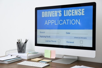 Computer with driver's license application form on table in office