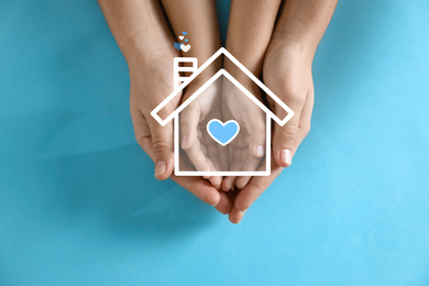 Image of Illustration of house and happy family holding hands on blue background, top view