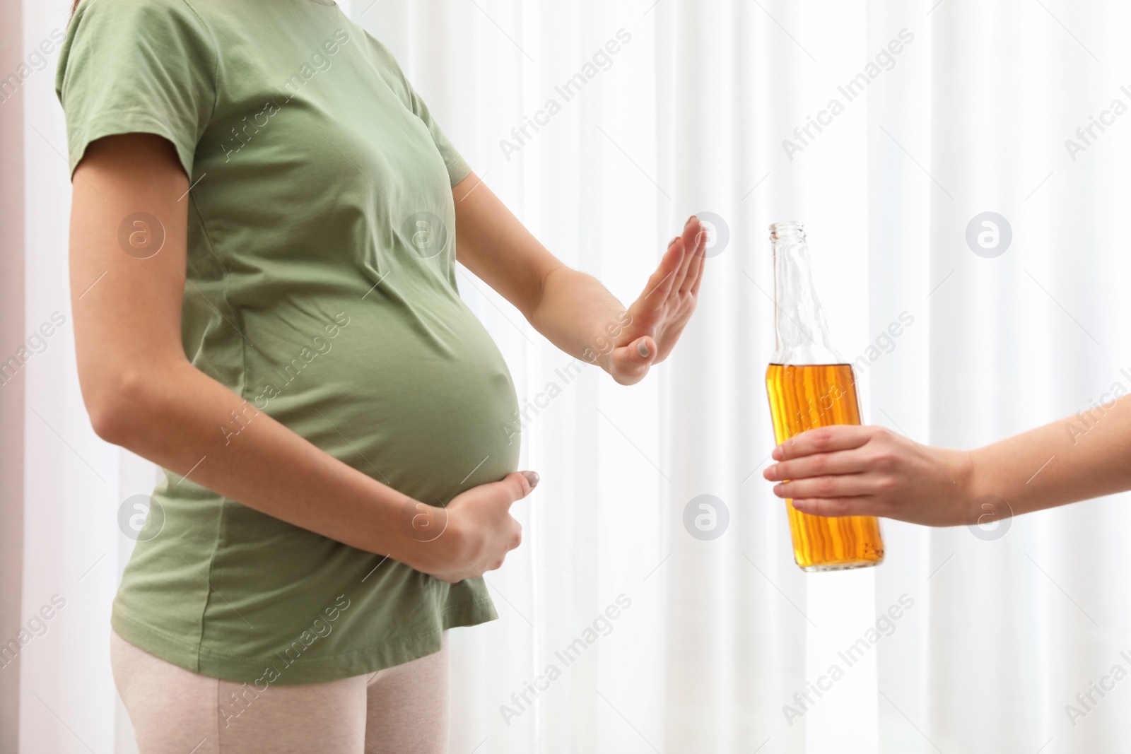 Photo of Pregnant woman refusing alcohol drink indoors, closeup. Bad habits during pregnancy