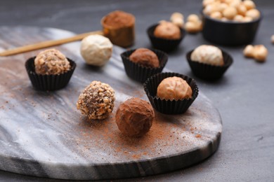 Different tasty chocolate candies on grey table