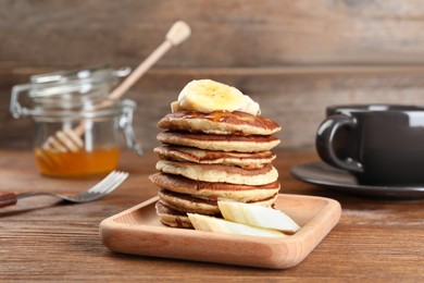 Plate of banana pancakes on wooden table